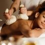 Woman having Thai herb compress massage in beauty spa